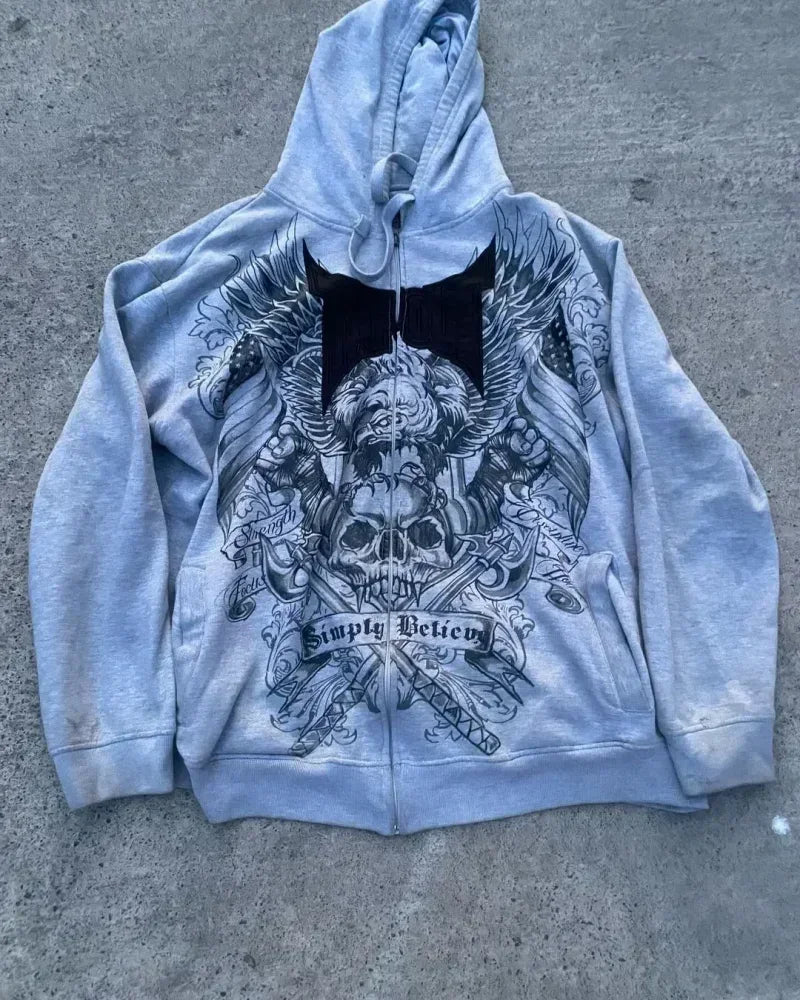 grey hoodie with black graphic design on a concrete surface
